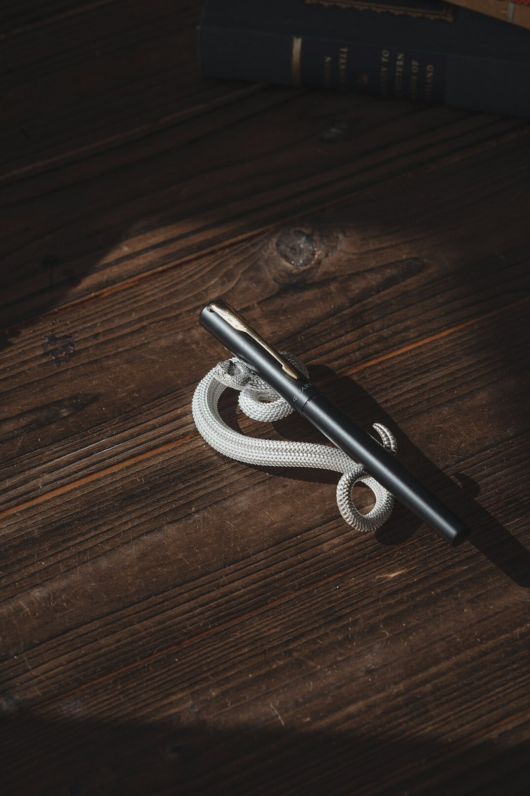 Pen writing in a notebook on a wooden desk